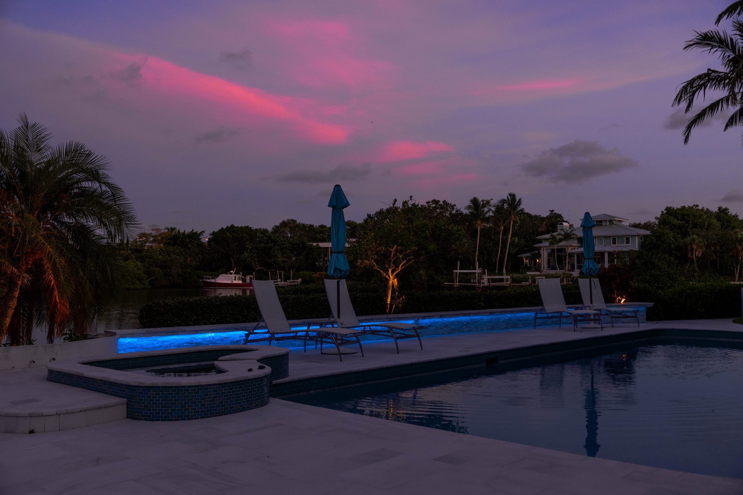 Poolside with glowing blue lights at sunset