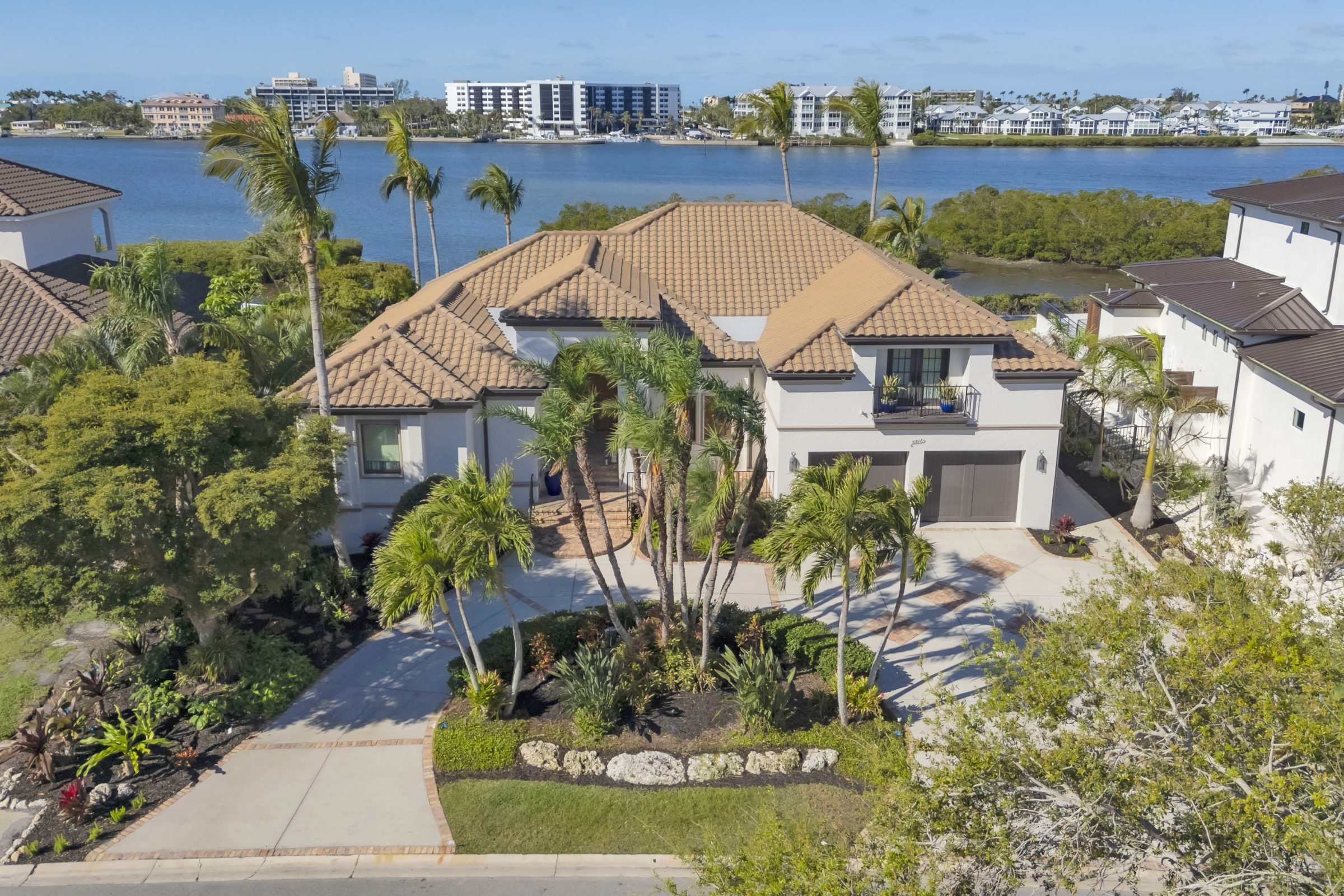 Waterfront home with lush tropical landscaping.