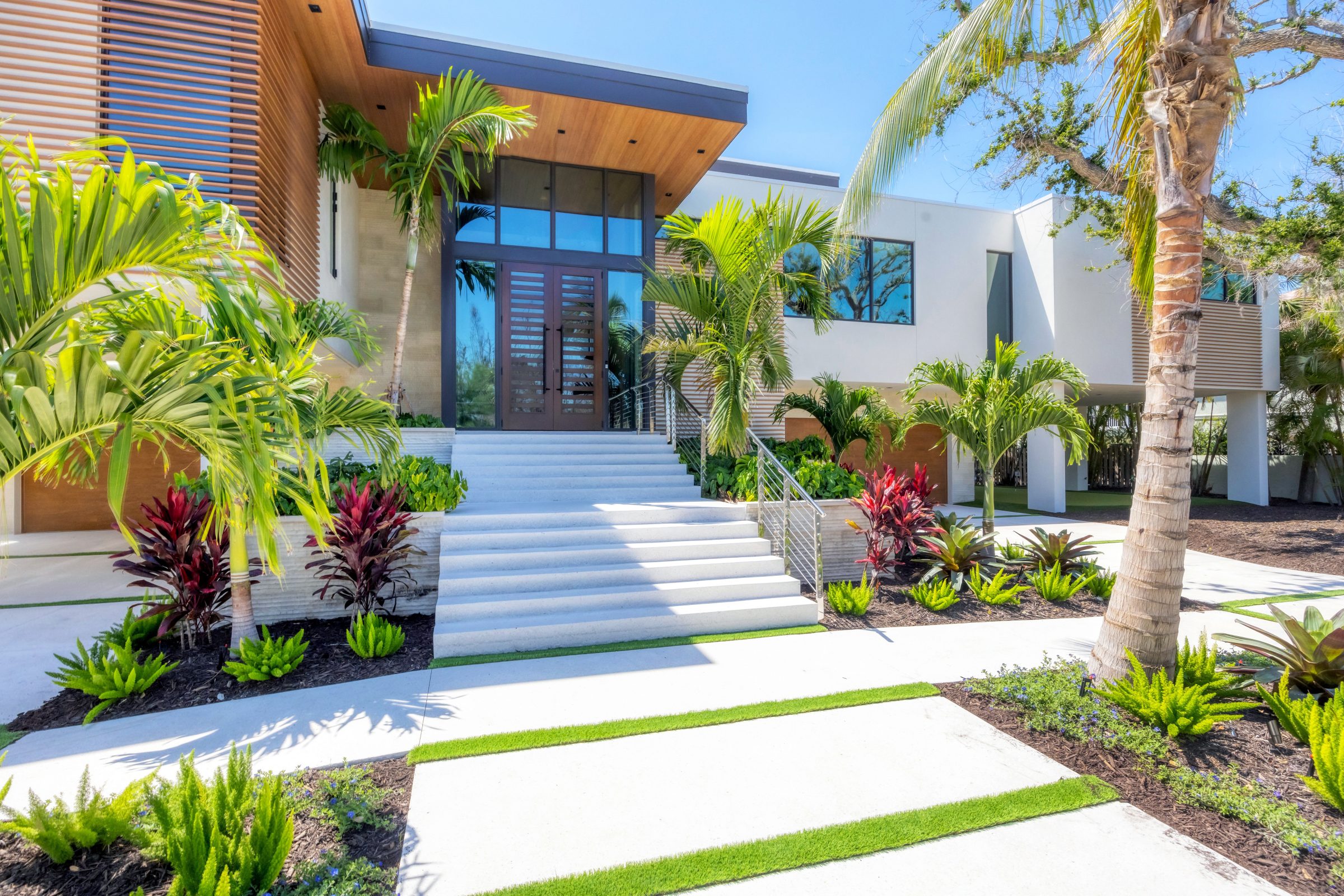 Modern home entrance with tropical landscaping.