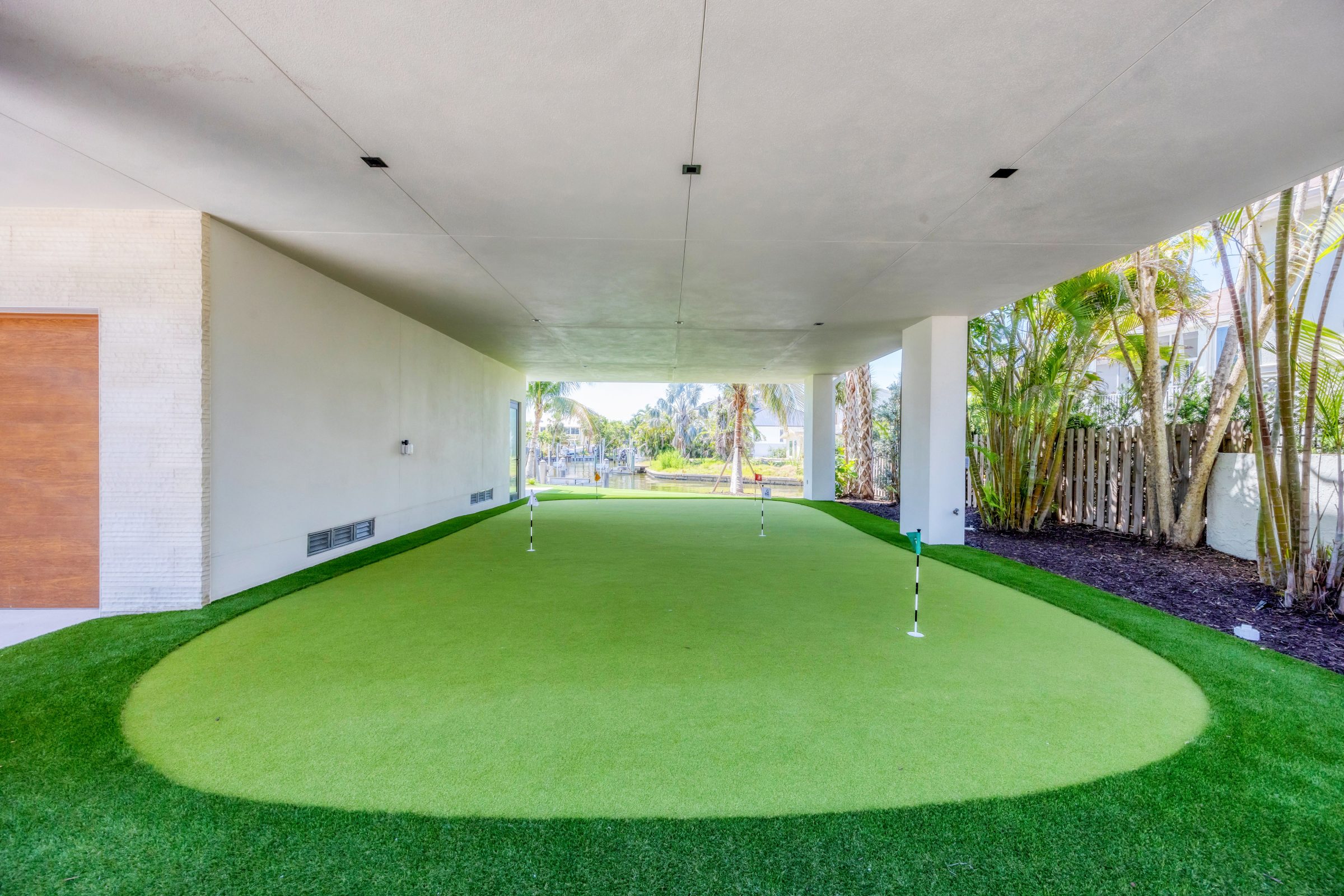 A shaded, artificial turf putting green area