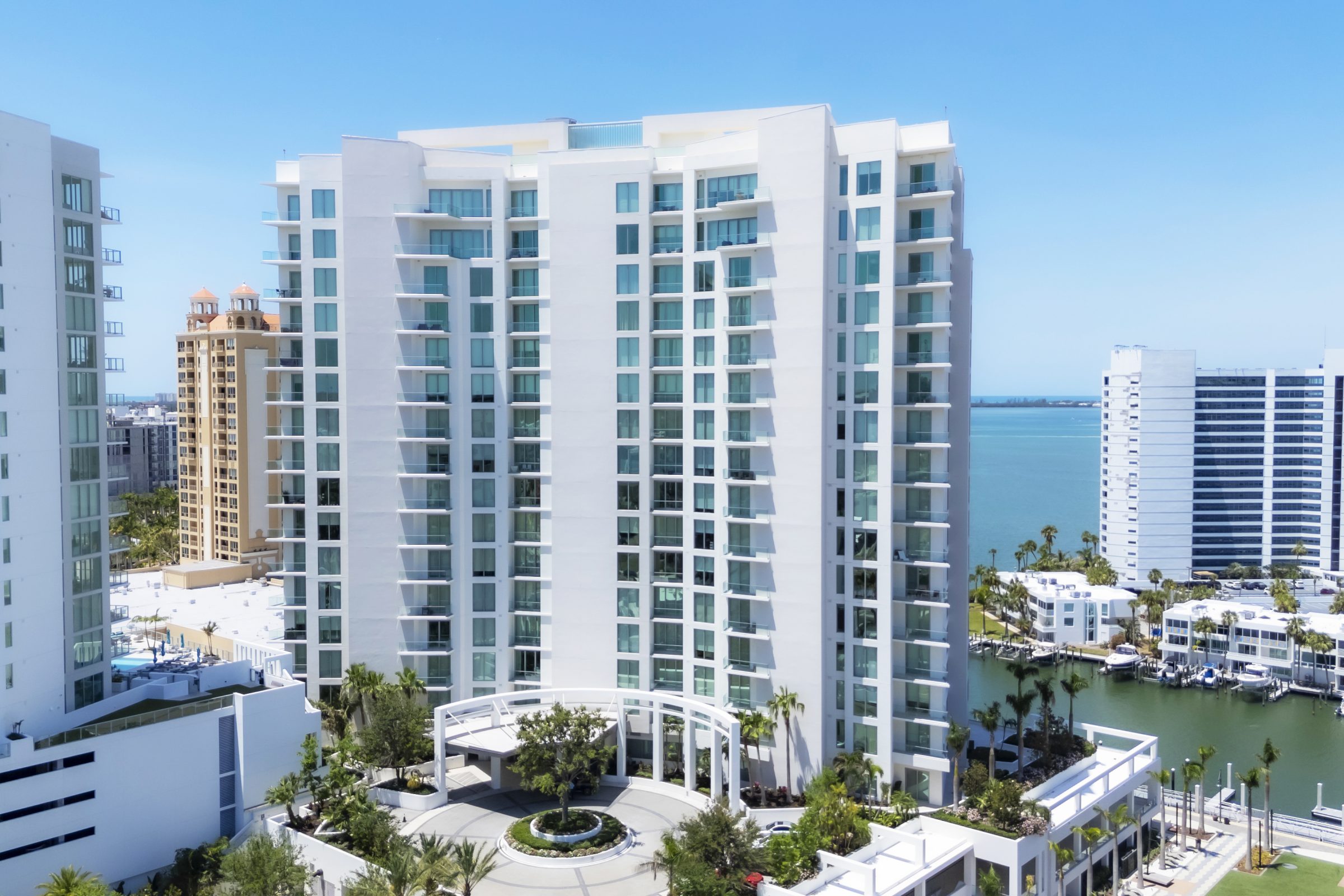 Tall waterfront high-rise building with circular entrance and views of the bay.